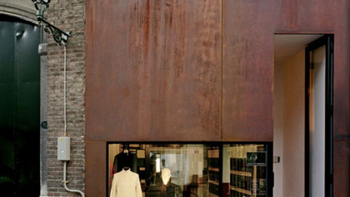 A fashion clothing shop with rusted-iron cladding in a brick building.