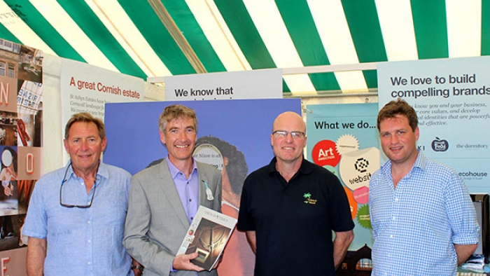 A group of men stand in a tent at Royal Cornwall Show.