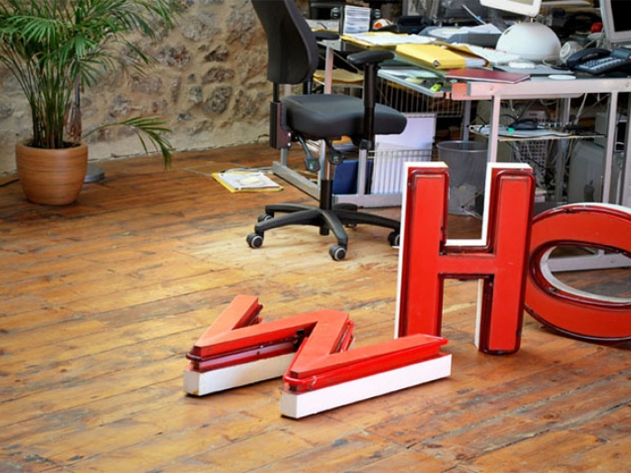 The Nixon Design studio, with wooden flooring and neon letters W, H and O, from an old Woolworth's sign.