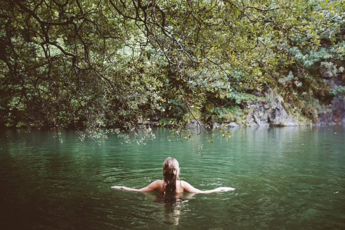 A woman swimming in a tranquil lake.