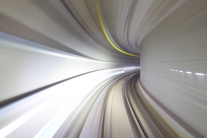 A motion-blurred photograph of a tunnel as a train speeds through it.