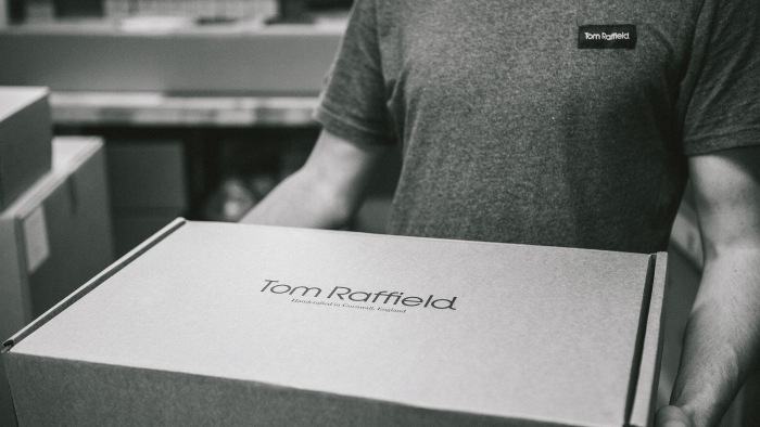 A man holding a Tom Raffield product box with the logo on top.