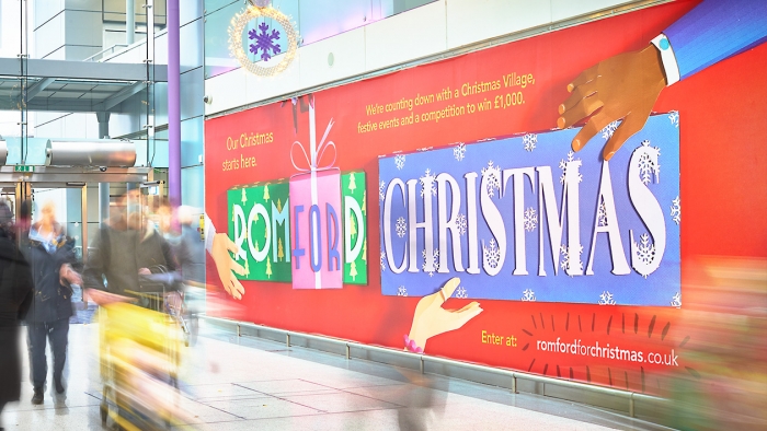Billboard in shopping centre reading 'Romford For Christmas'.