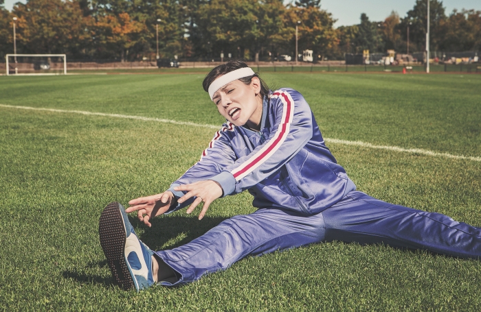 Athlete stretching in purple tracksuit. 