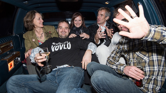 A group talks in the back of a vintage limo.